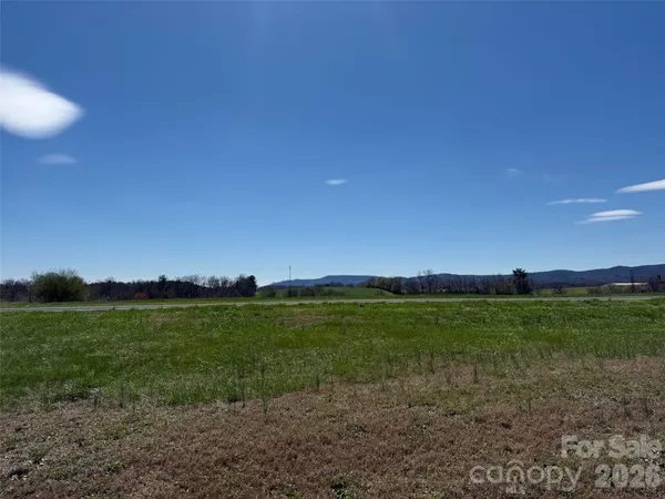 a view of a field with trees in the background
