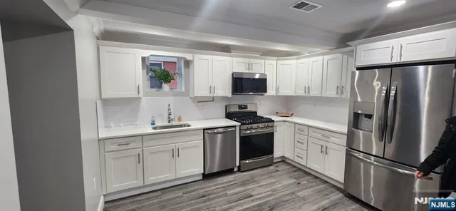 a kitchen with stainless steel appliances a refrigerator sink and microwave