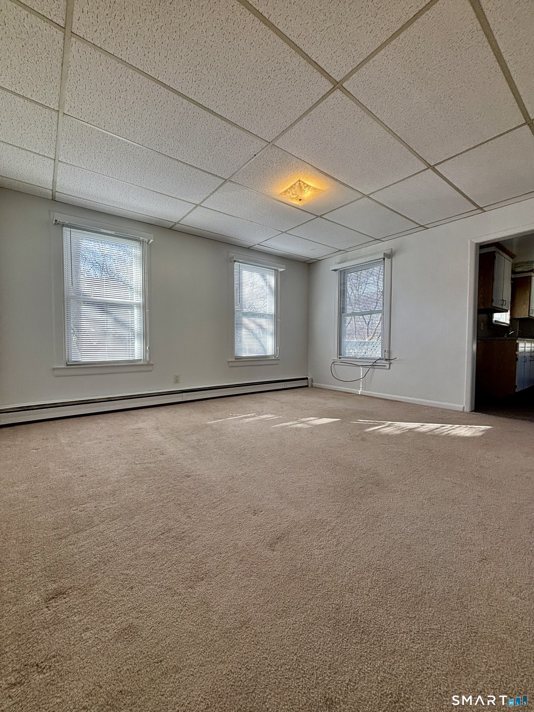 73 Peck Street, Unit 2 Norwich, CT 06360 - Photo 4 of 10 an empty room with windows and closet
