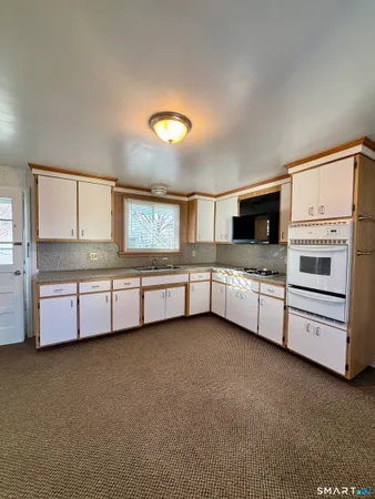 a kitchen with stainless steel appliances a stove and white cabinets