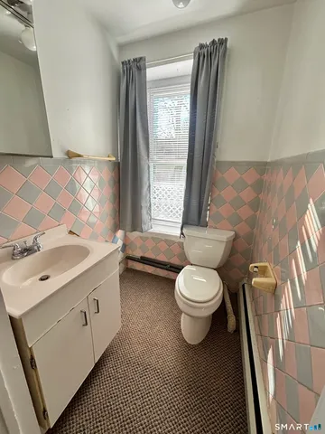 a bathroom with a toilet a sink and mirror