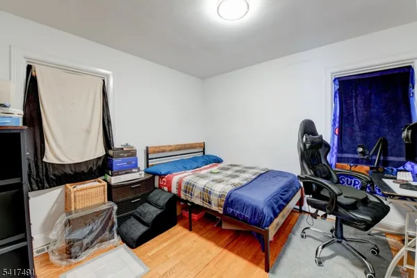 a kitchen with stainless steel appliances a stove a refrigerator a sink a dining table and chairs with wooden floor