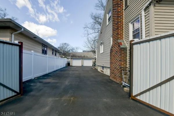 a view of backyard with wheel chair and iron fence