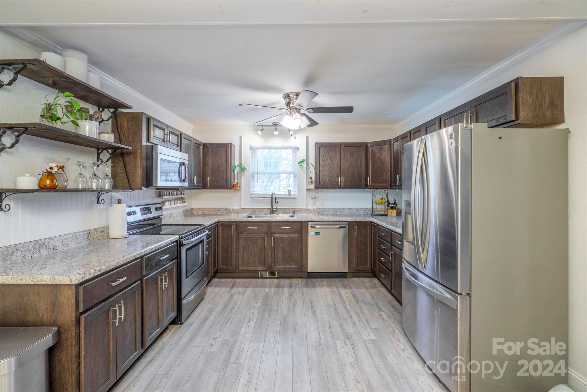 1072 5th Street Northeast Hickory, NC 28601 - Photo 12 of 27 a kitchen with stainless steel appliances granite countertop a refrigerator a sink dishwasher a kitchen island with wooden cabinets and floor