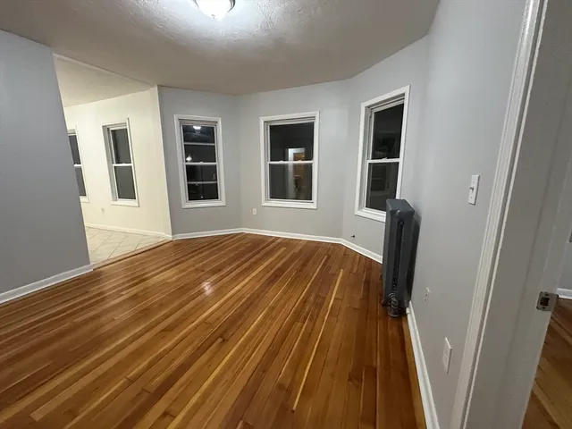 a view of a bedroom with wooden floor and front door