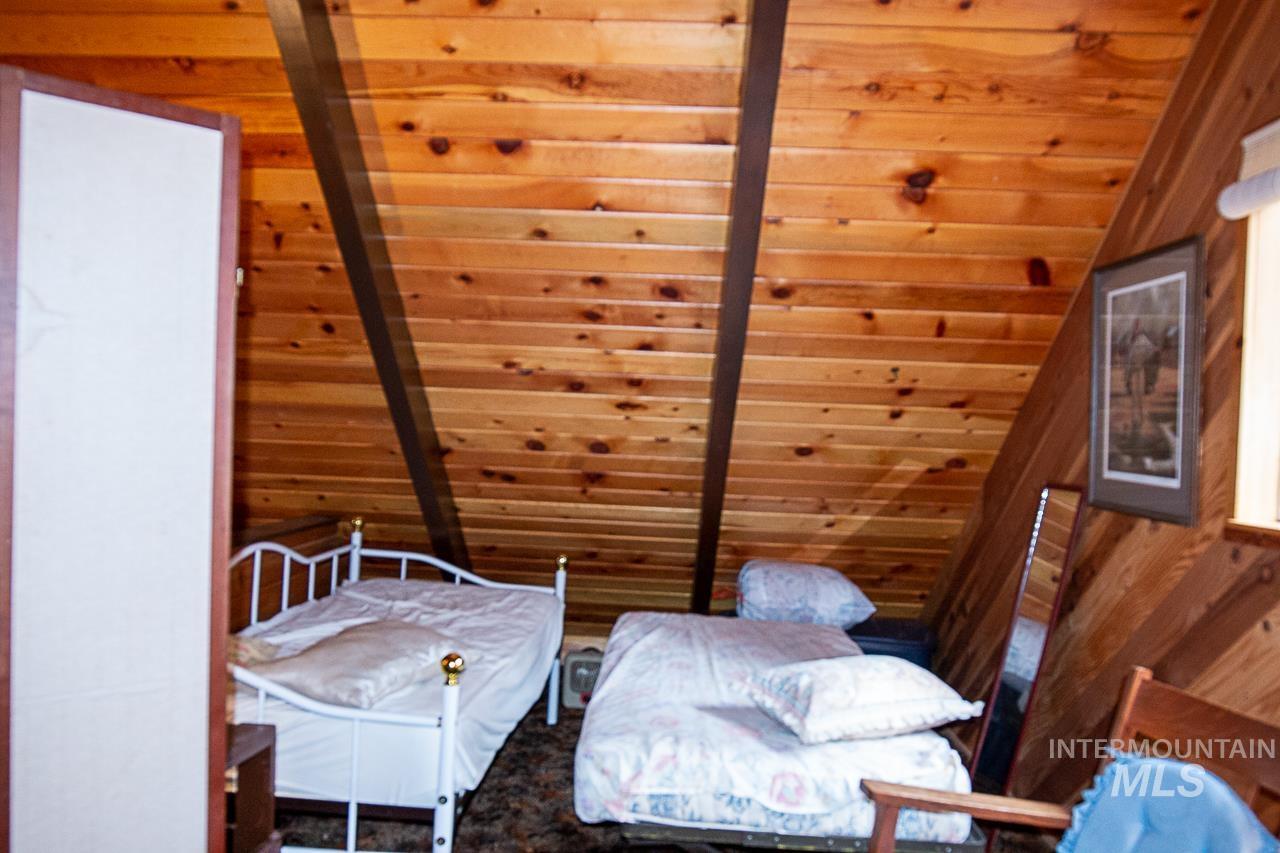 225 Mesplie Road Placerville, ID 83666 - Photo 25 of 39 Living area with vaulted ceiling, wooden walls, and wood ceiling