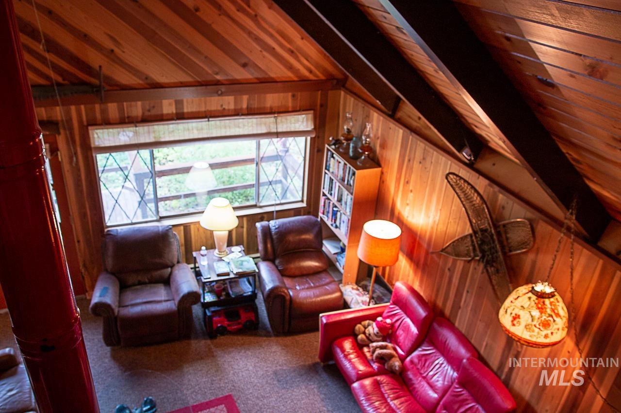 225 Mesplie Road Placerville, ID 83666 - Photo 33 of 39 Living room featuring wood walls and carpet flooring