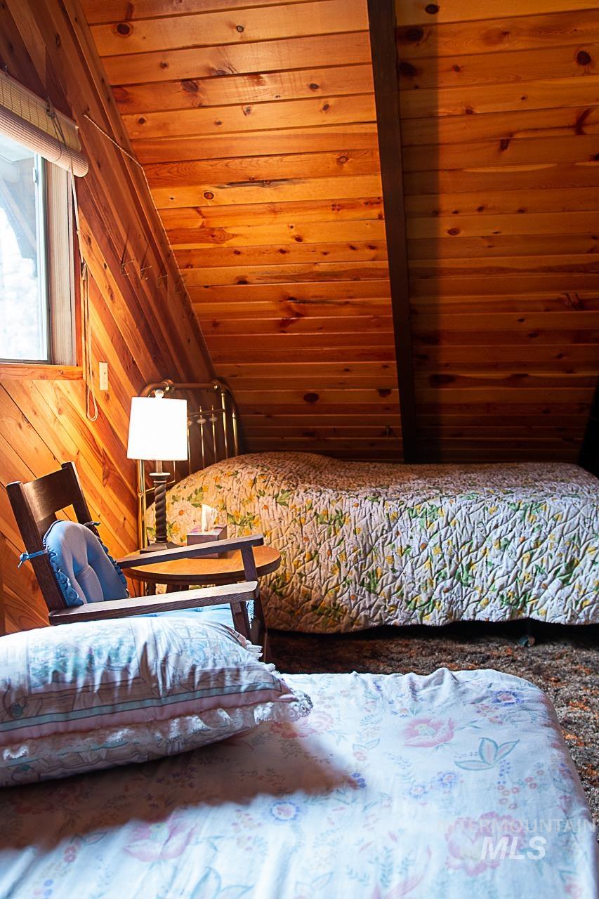 225 Mesplie Road Placerville, ID 83666 - Photo 34 of 39 Bedroom with vaulted ceiling, wood ceiling, and wooden walls