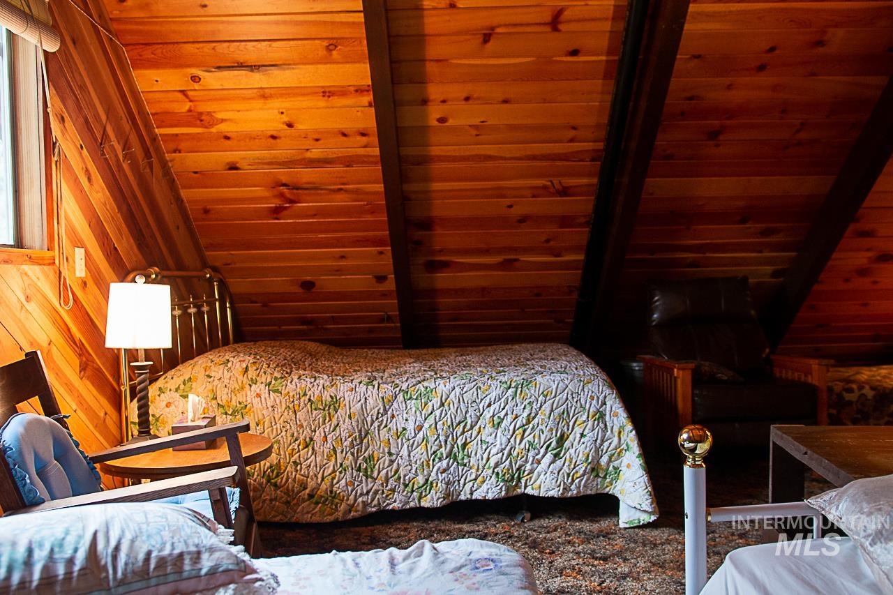 225 Mesplie Road Placerville, ID 83666 - Photo 35 of 39 Bedroom with lofted ceiling, wood walls, and wooden ceiling
