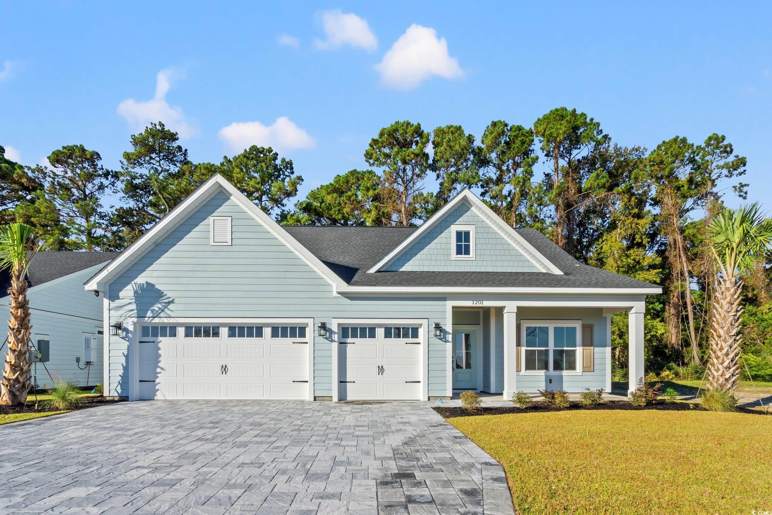 1201 Crooked Hook Road North Myrtle Beach, SC 29582 - Photo 1 of 23 View of front of house with a front yard, decorative driveway, a porch, and roof with shingles