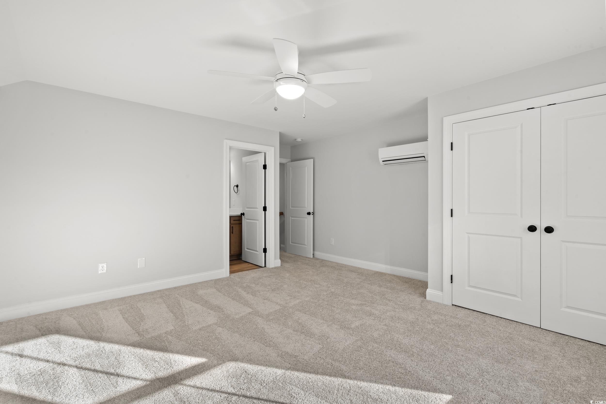 1201 Crooked Hook Road North Myrtle Beach, SC 29582 - Photo 5 of 23 Unfurnished room featuring light carpet, a wall unit AC, and a ceiling fan