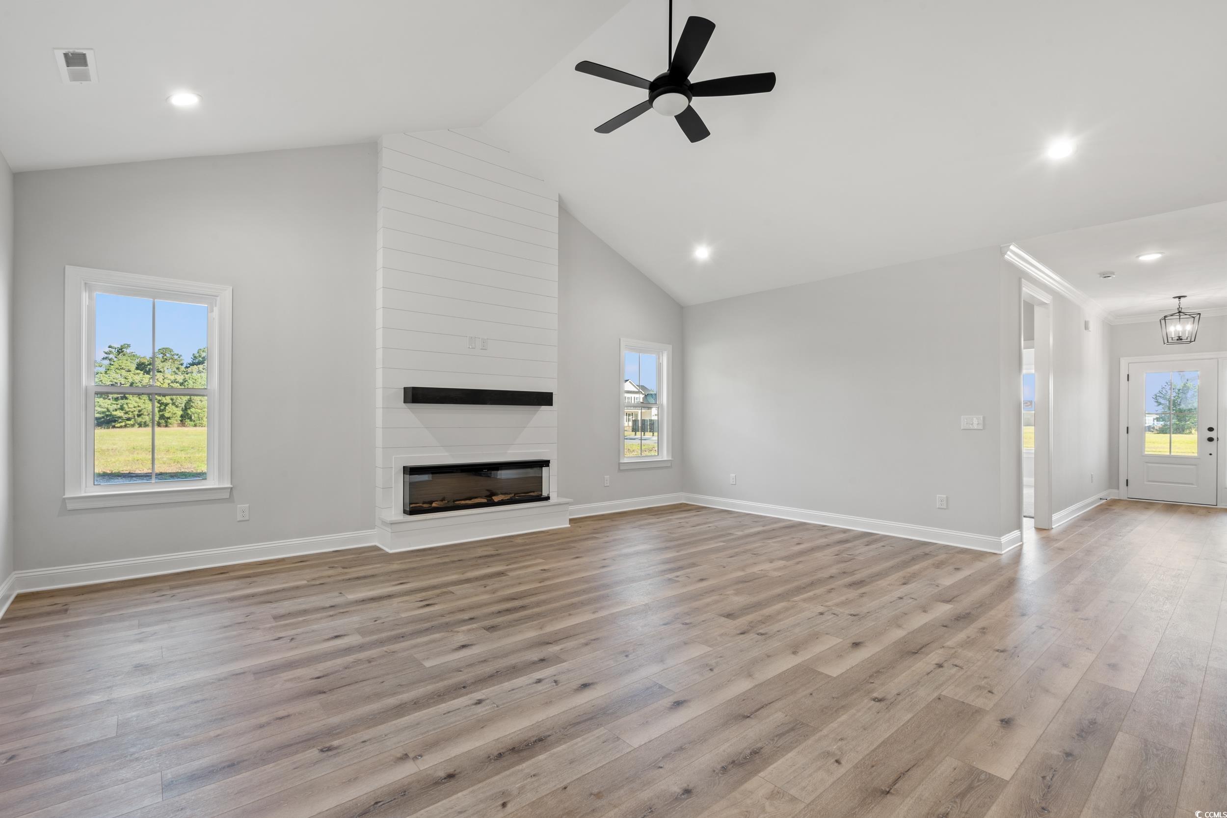 1201 Crooked Hook Road North Myrtle Beach, SC 29582 - Photo 10 of 23 Unfurnished living room with light wood finished floors, stairs, ceiling fan, lofted ceiling, and recessed lighting