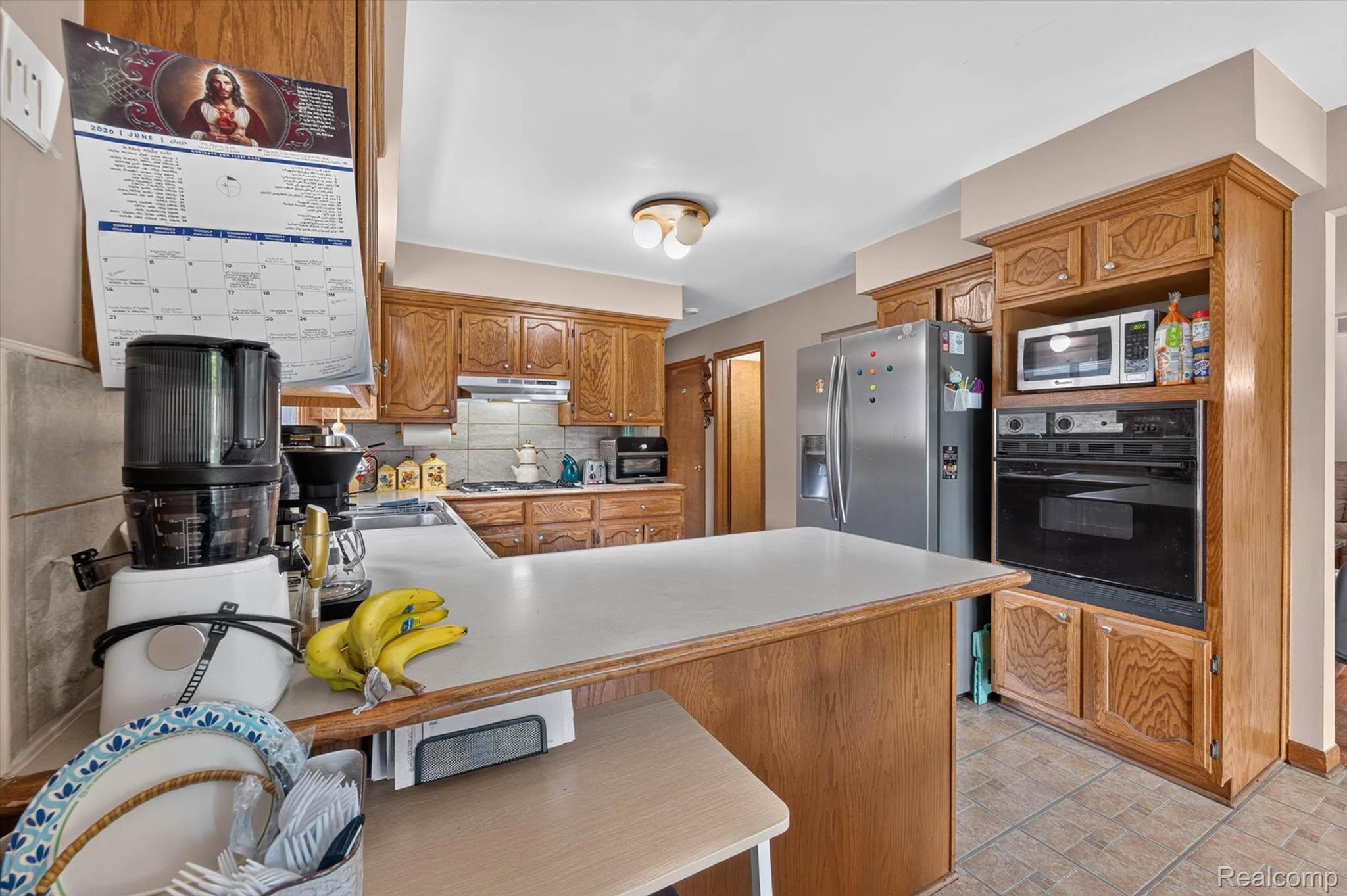46362 Springhill Drive Utica, MI 48317 - Photo 12 of 59 Kitchen featuring wood-finish cabinetry, solid surface countertops, and an integrated wall oven