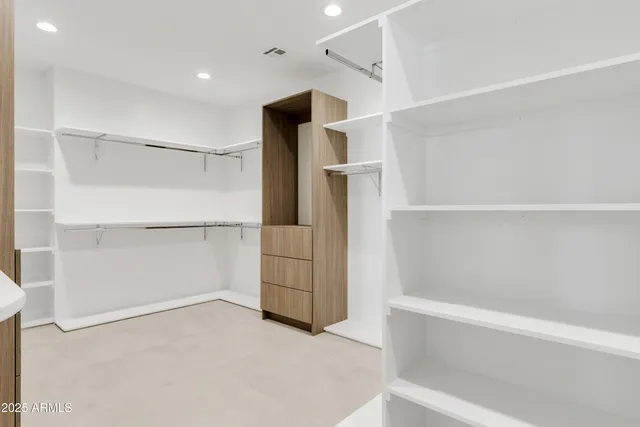 a view of walk in closet with empty racks