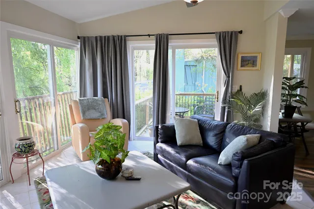 a living room with furniture potted plant and a large window