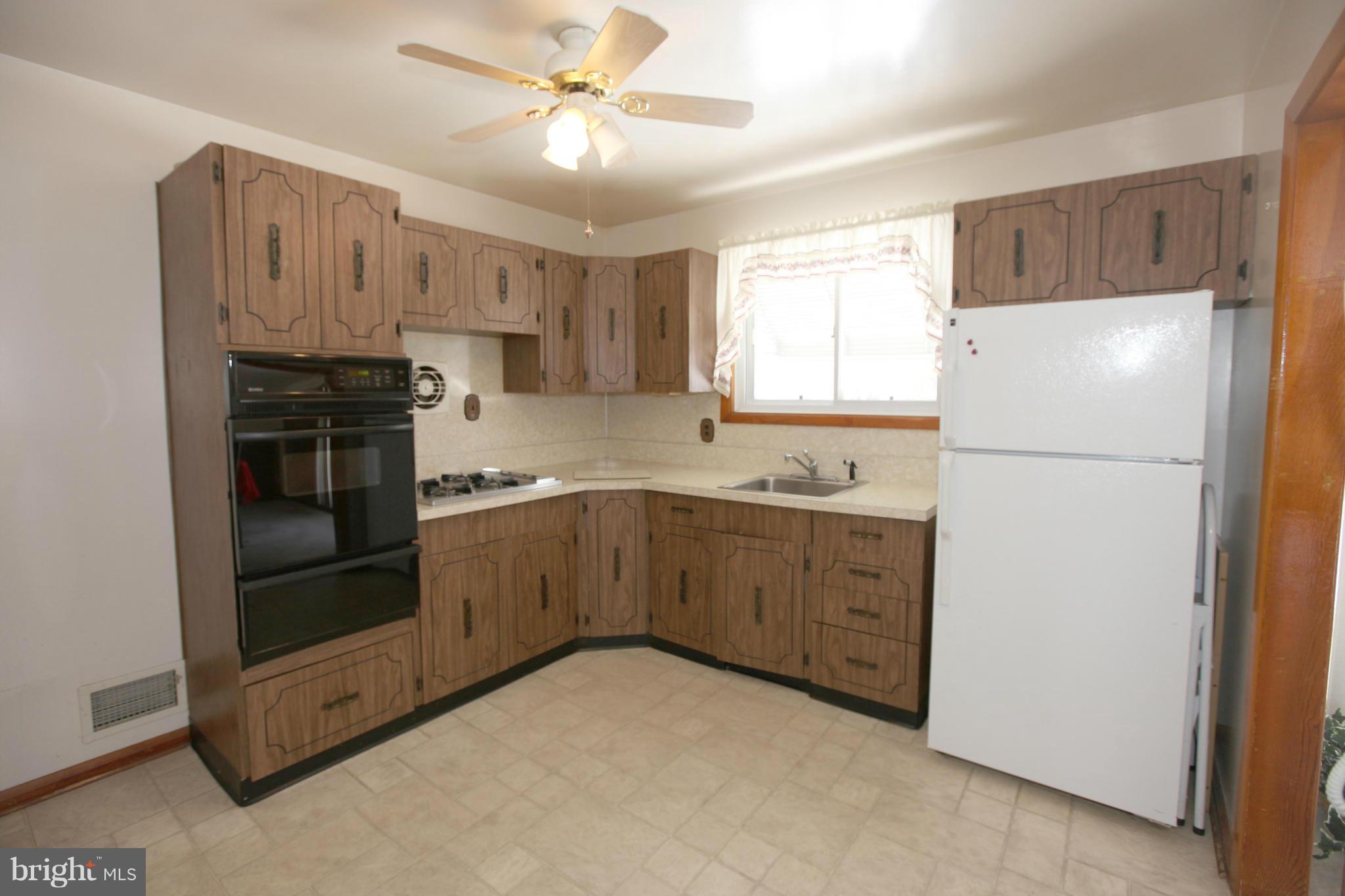 1808 Willann Road Baltimore, MD 21237 - Photo 7 of 23 a kitchen with granite countertop a refrigerator and a stove top oven