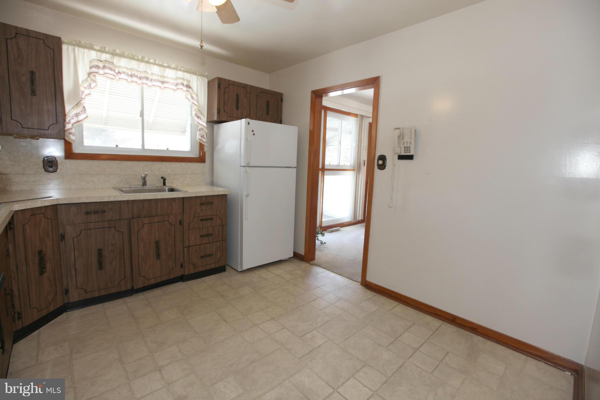 1808 Willann Road Baltimore, MD 21237 - Photo 9 of 23 a kitchen with cabinets a refrigerator and a sink