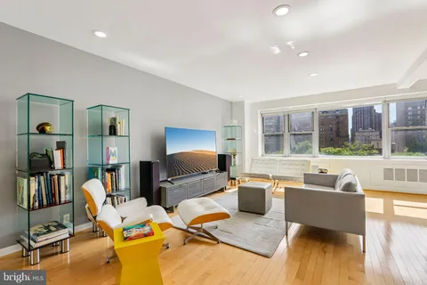 a living room with furniture and a flat screen tv with wooden floor