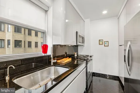 a kitchen with stainless steel appliances a stove a sink and a microwave