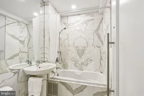 a bathroom with a granite countertop sink a toilet and shower