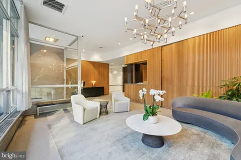 a living room with furniture gym equipment and large windows