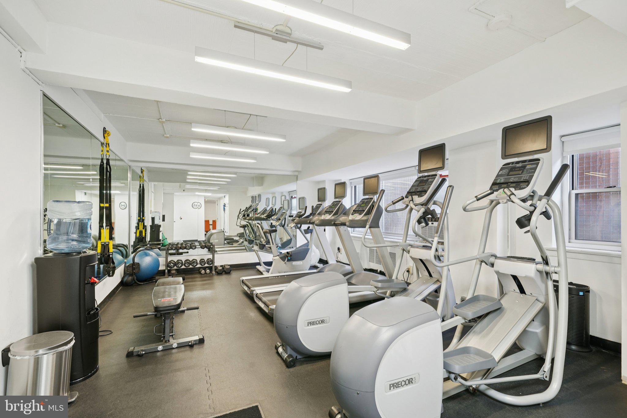 220 West Rittenhouse Square, Unit 10C Philadelphia, PA 19103 - Photo 33 of 39 a living room with furniture gym equipment and large windows
