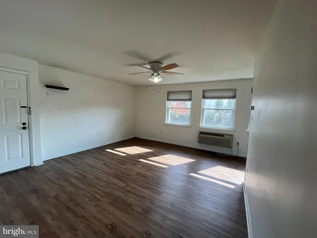 a view of a hallway with wooden floor and closet