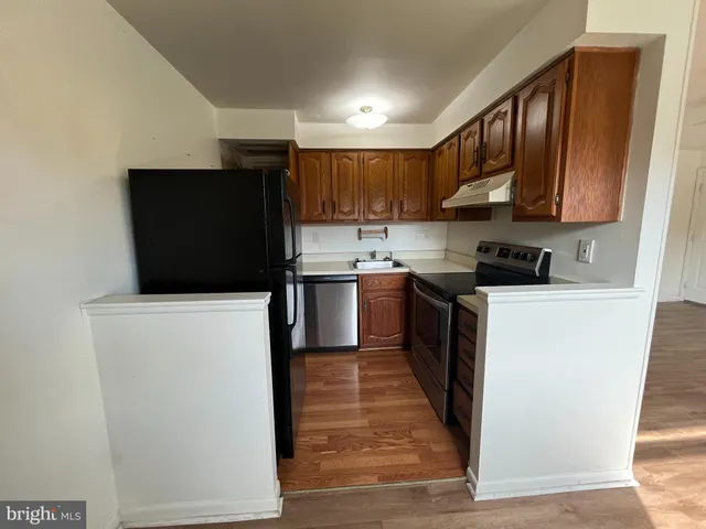 a kitchen with granite countertop a refrigerator stove a sink and dishwasher