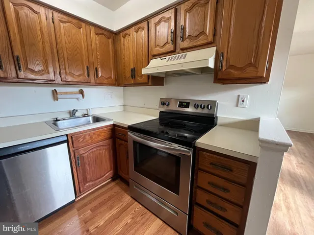 a kitchen with a sink a refrigerator and cabinets