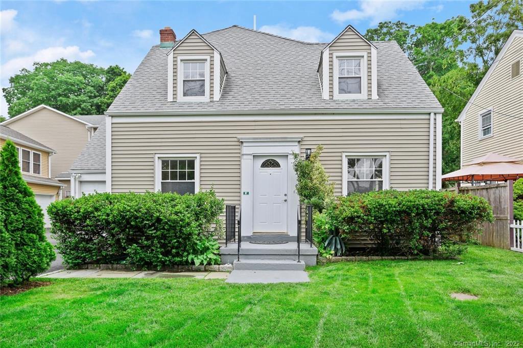a front view of a house with a garden and plants