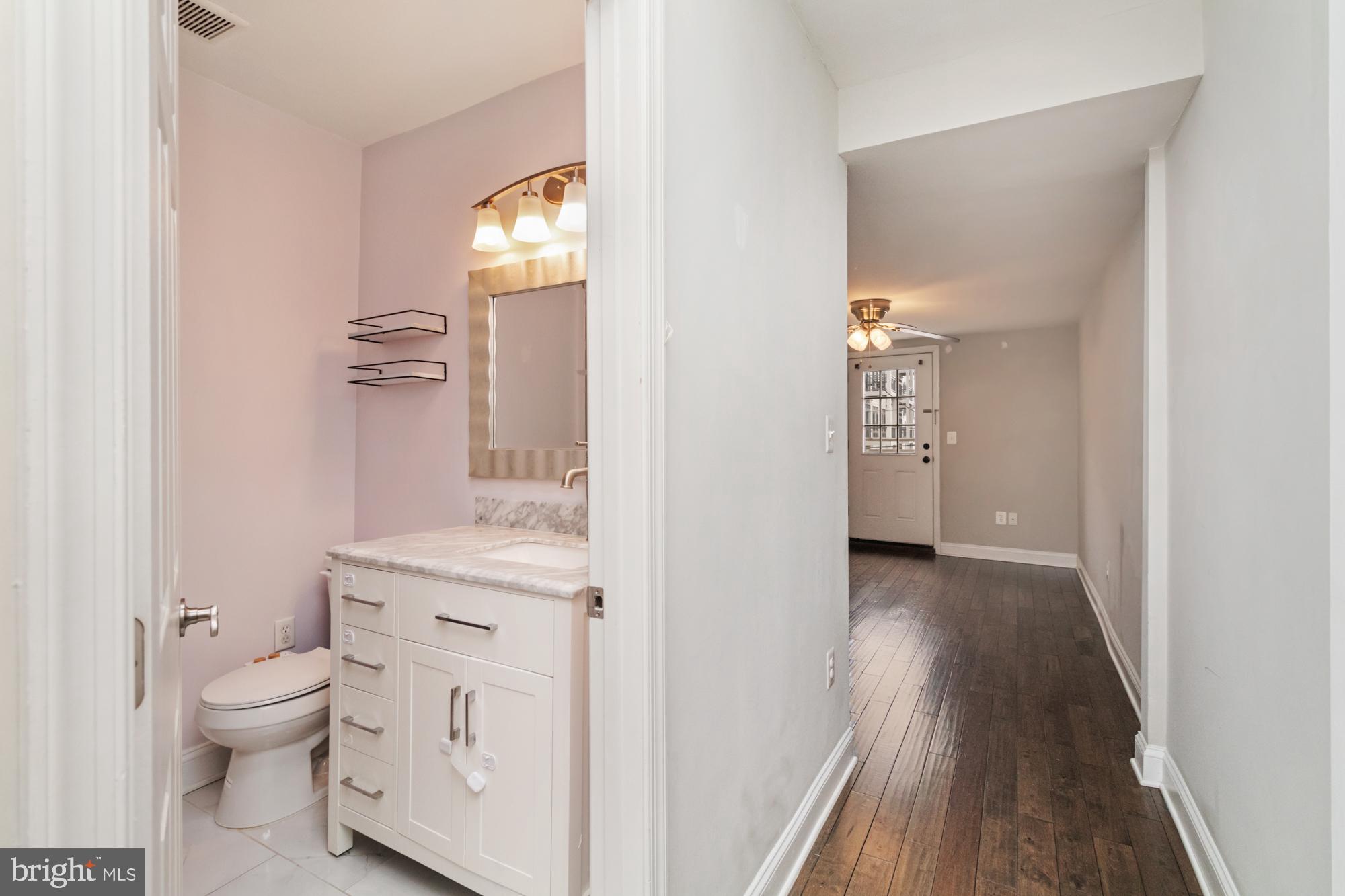 1812 Light Street Baltimore, MD 21230 - Photo 19 of 45 a bathroom with a granite countertop toilet and a sink