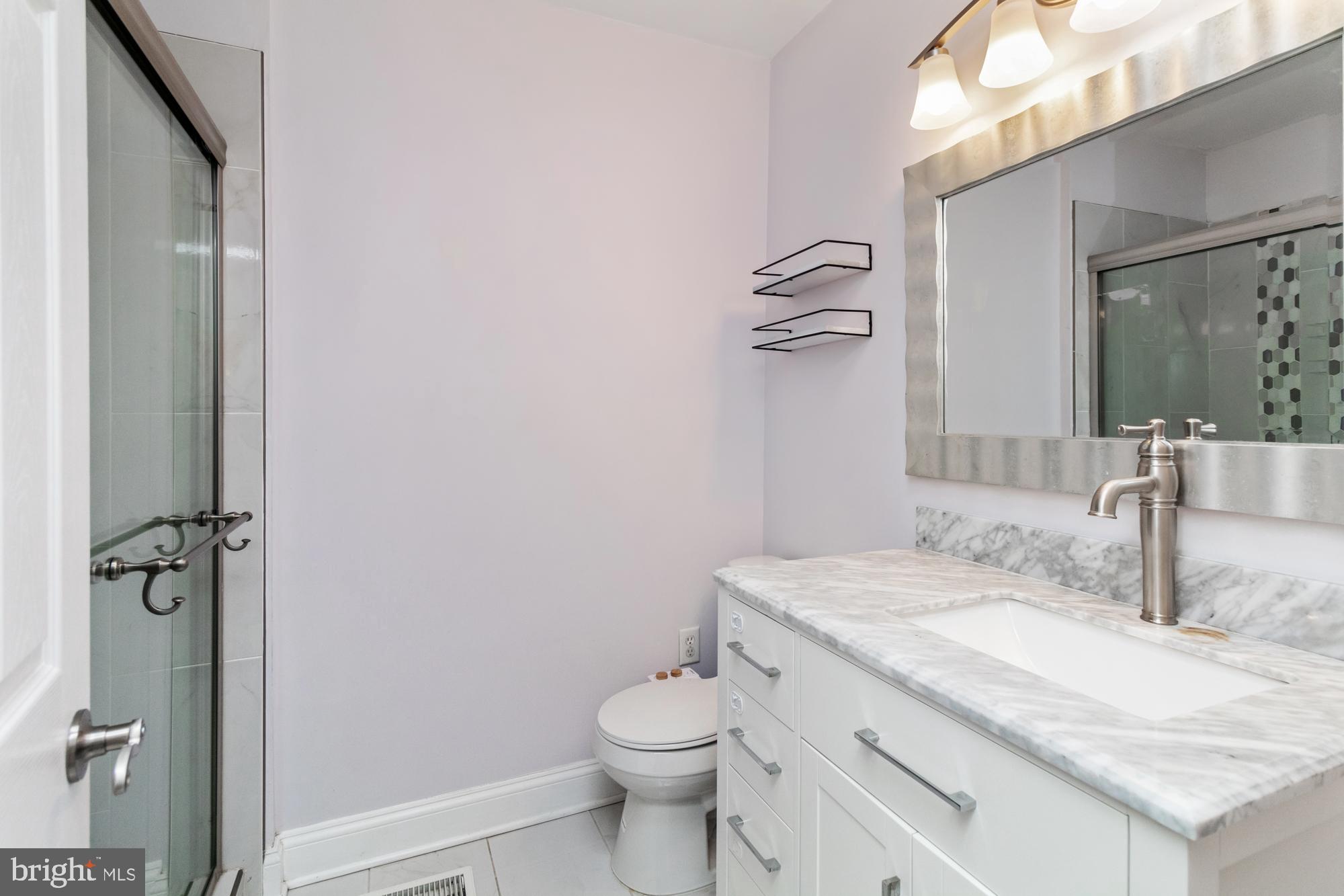 1812 Light Street Baltimore, MD 21230 - Photo 24 of 45 a bathroom with a granite countertop sink a toilet and a mirror
