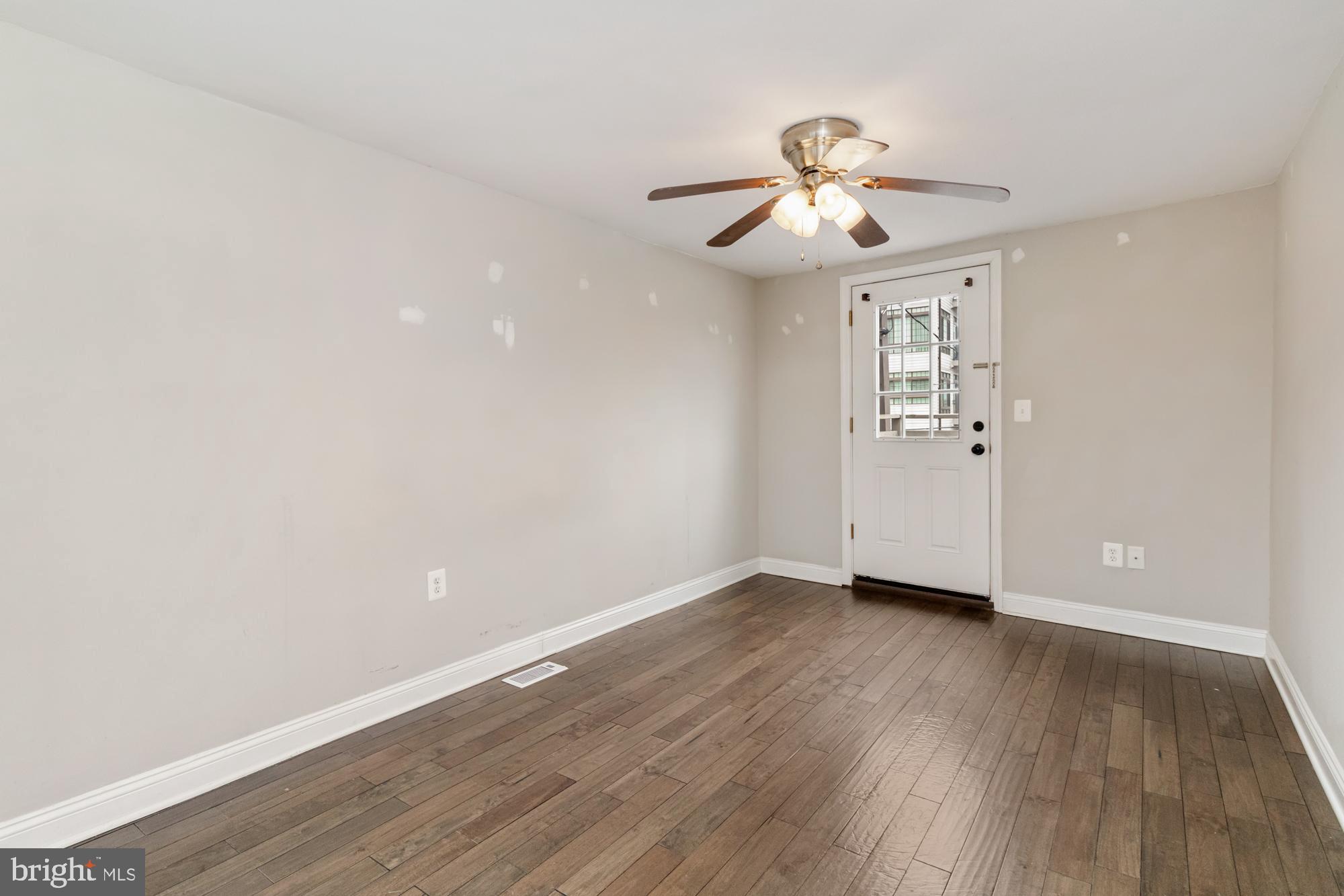 1812 Light Street Baltimore, MD 21230 - Photo 26 of 45 an empty room with wooden floor chandelier fan and windows