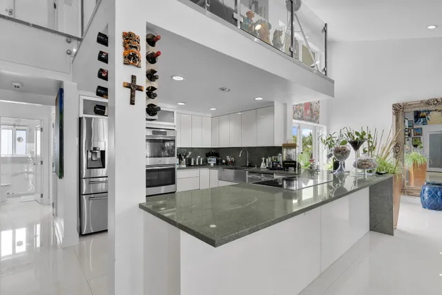 a kitchen with stainless steel appliances granite countertop a sink dishwasher and a refrigerator