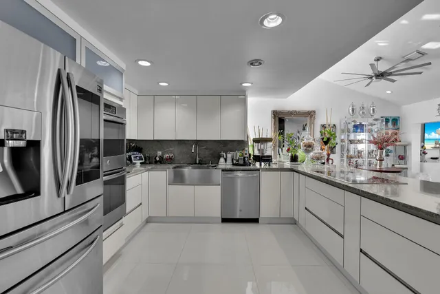 a kitchen with stainless steel appliances granite countertop a refrigerator and a sink