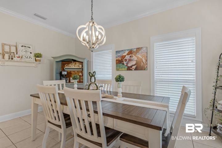 24541 Baldwin Beach Expressway Robertsdale, AL 36567 - Photo 12 of 51 Dining area with light tile patterned floors, ornamental molding, baseboards, visible vents, and a notable chandelier
