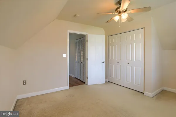 an empty room with a ceiling fan and a shower