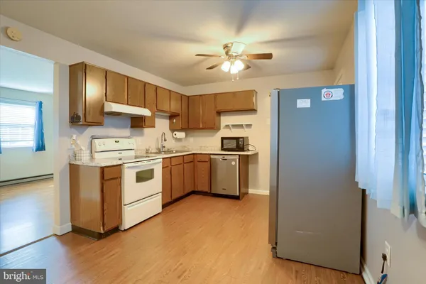 a kitchen with white cabinets and white appliances