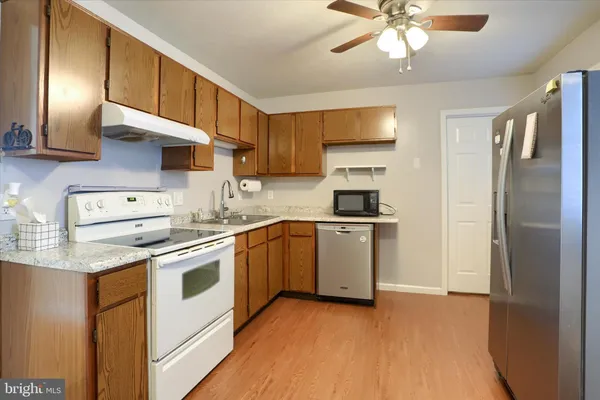 a kitchen with a sink stainless steel appliances and white cabinets