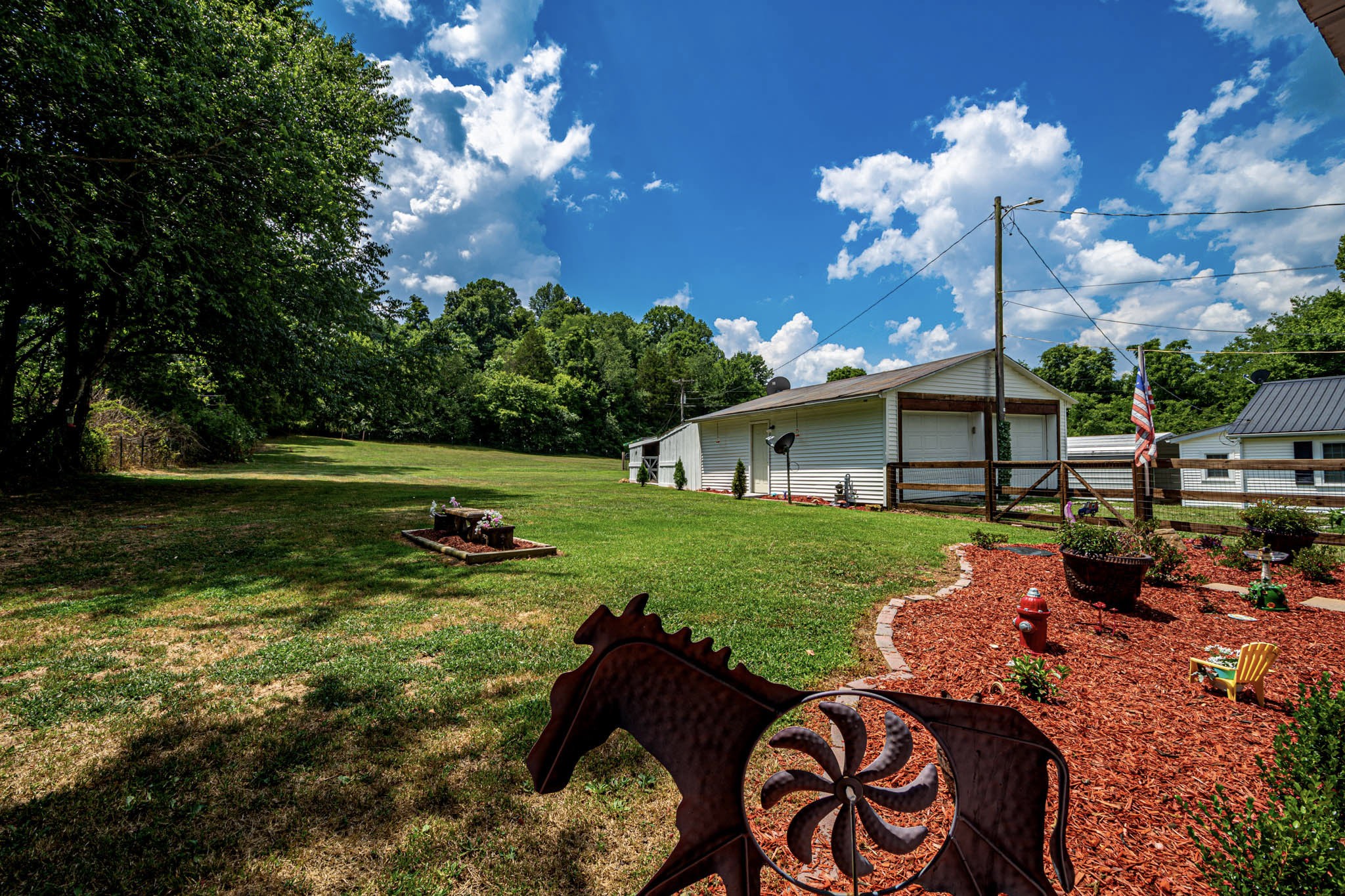 7091 Morgan Creek Road Centerville, TN 37033 - Photo 47 of 55 a backyard of a house with table and chairs plants and large trees