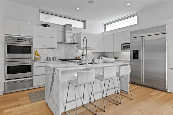 a large kitchen with stainless steel appliances kitchen island granite countertop a sink and cabinets