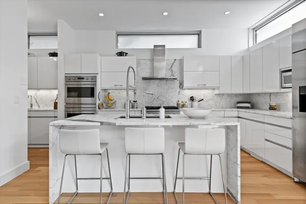 a kitchen with kitchen island a white counter top space a sink cabinets and appliances