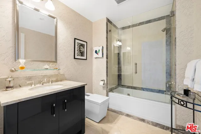 a bathroom with a tub sink mirror and a toilet