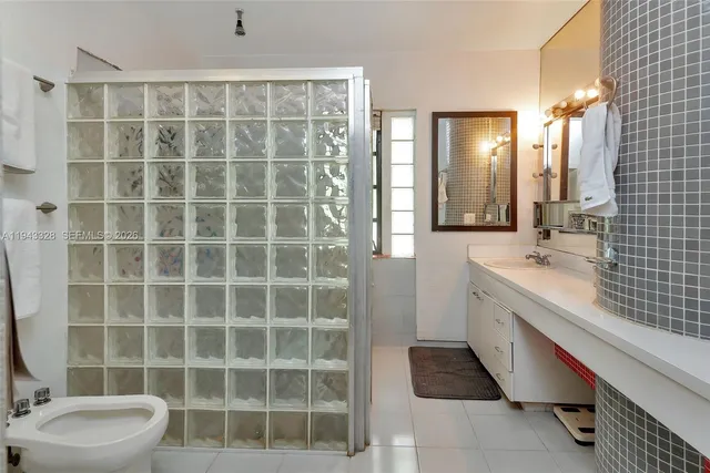 a bathroom with a double vanity sink a toilet and a mirror