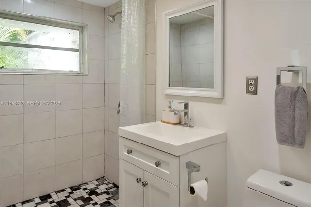 a bathroom with a sink a toilet and a window