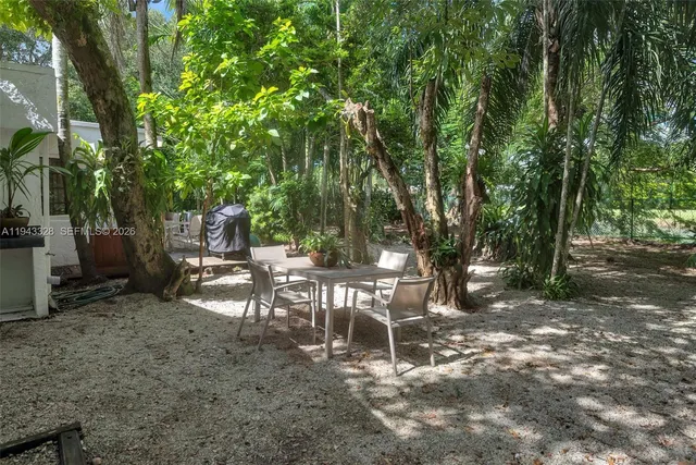a view of a backyard with a table and chairs