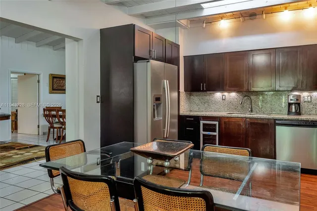 a kitchen with stainless steel appliances kitchen island granite countertop furniture and a refrigerator