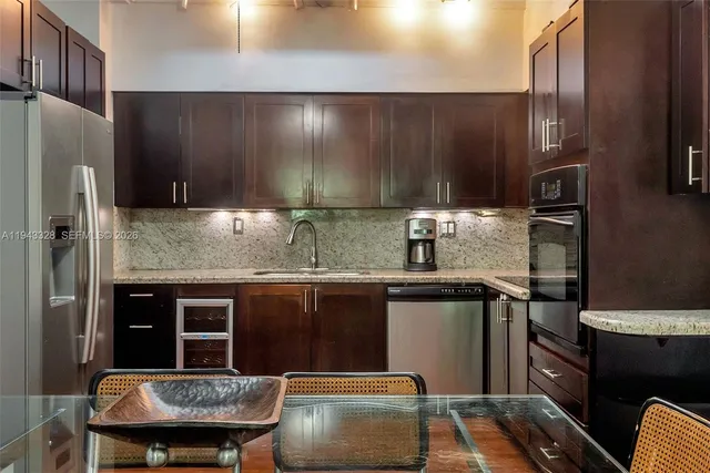 a kitchen with granite countertop a refrigerator stove and sink