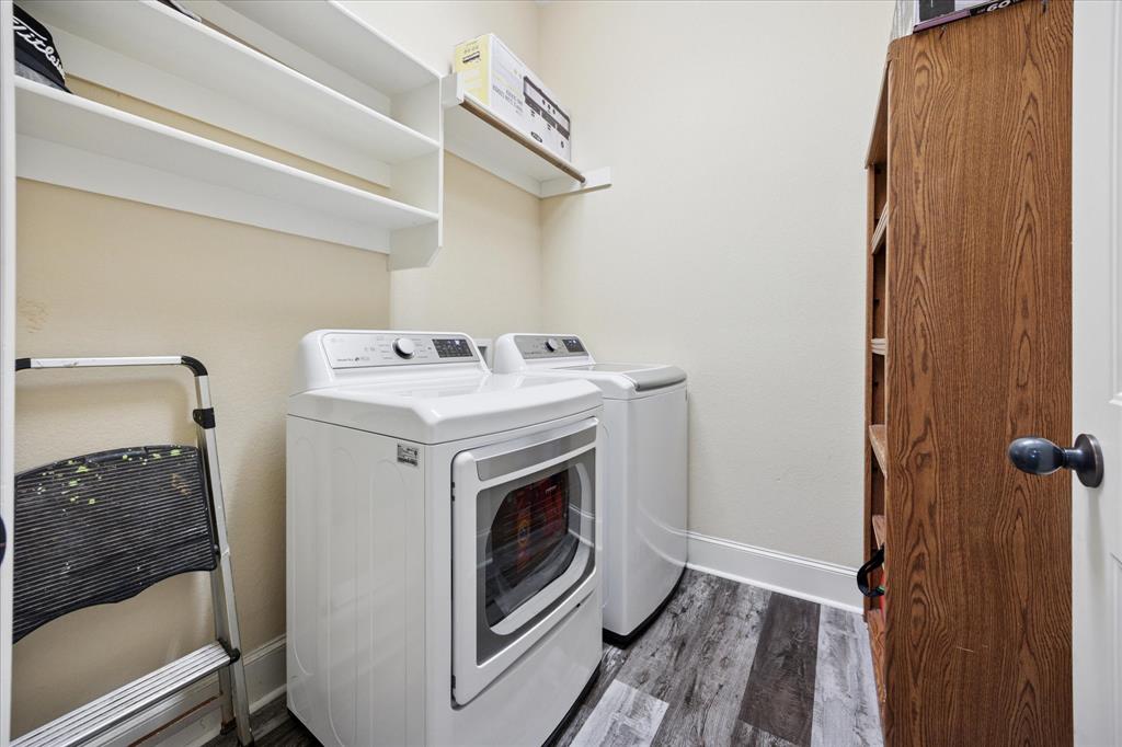 119 George Owens Road Ponder, TX 76259 - Photo 20 of 26 Laundry area featuring white built-in shelving, wood-finish flooring, and a stand-alone wood-finish storage unit