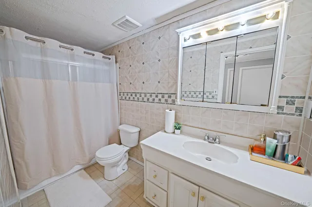 a bathroom with a sink a toilet and shower curtain